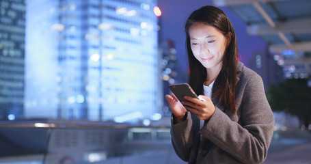 Businesswoman use of mobile phone at night