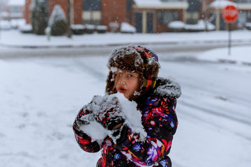 Cute asian girl smiling outdoors in snow on cold winter day