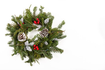 Christmas festive decoration with red baubles, holly with red berries , snow covered pine cones and winter greenery with copy space.