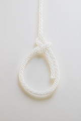 Close up white rope bowline knot on a white background.