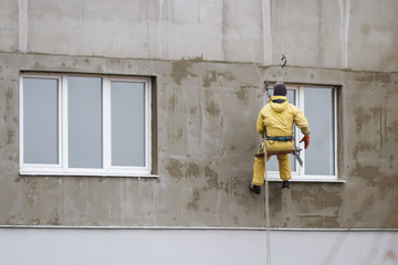 Thermal insulation of the exterior wall panel. Worker man insulates wall high-rise building