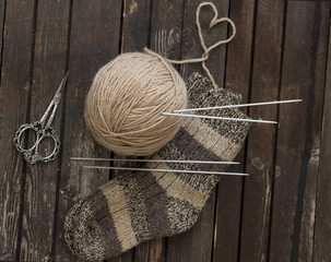 on a wooden table, threads, socks, knitting needles, a tangle of threads - everything for knitting