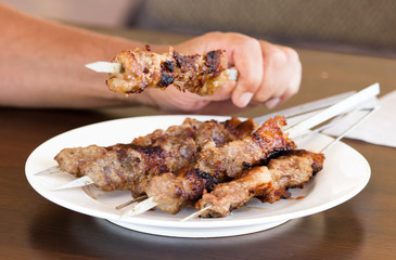 fried meat on metal sticks in a cafe