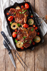 Delicious T Bone steak with grilled vegetables on the grill pan close-up. Vertical top view