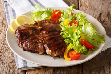  Delicious grilled T-bone steak with fresh vegetable and lemon close-up. horizontal © FomaA