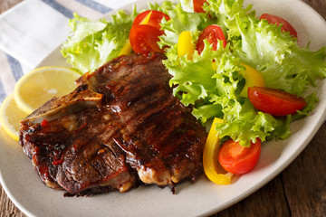 Spicy T-Bone steak with fresh vegetable and lemon close-up. horizontal