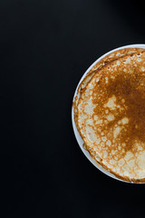Russian pancakes on black background