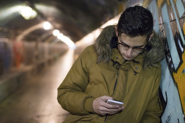Fototapeta premium young with mobile phone in the underground of the city
