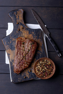Beef steak on cutting board and pepper
