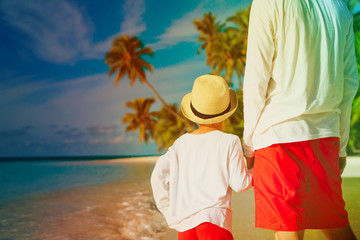 Fototapeta na wymiar father and son holding hands on beach
