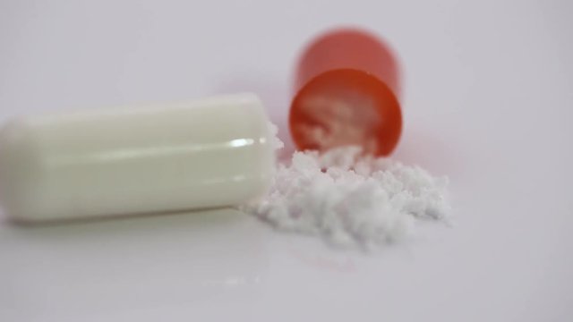 Pharmaceuticals and drugs, view of the opened capsule with medicine, isolated.
