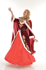 full length portrait of pretty blonde lady wearing red and white christmas inspired costume gown, standing pose on white background.