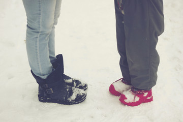 feet adult and child on winter road