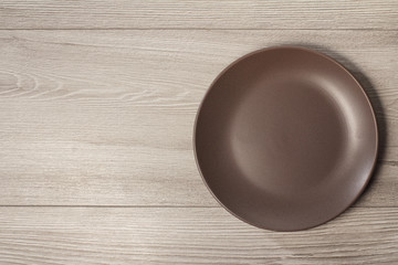 Fototapeta na wymiar Empty ceramic plate on grey wooden background with copy space
