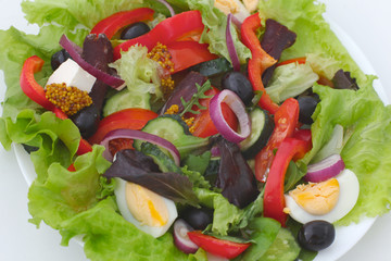 salad from fresh vegetables in a plate on a table, selective focus