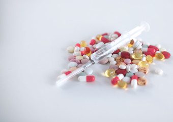 stethoscope, syringe and a plate of tablets on a table