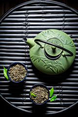 Closeup of green tea in teacup on black bamboo table