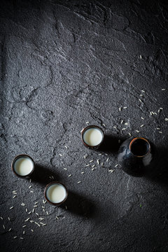 White sake in black ceramics on black rock