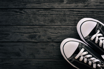 Sneakers, sports shoes on a wooden background. Top view. Free space for text.