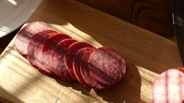 Slicing sausage on a cutting board. Beef sausage. Cut with a kitchen knife.