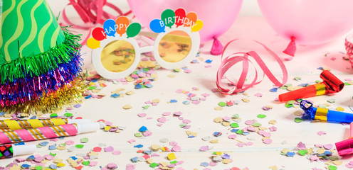 Birthday party. Confetti and serpentines on wooden background
