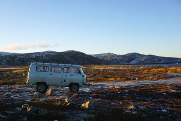 Vintage blue van parking on tundra arctic landscape