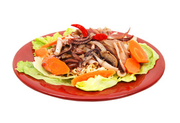 Pasta with seafood: octopus, squid decorated with chili and carrot, salad