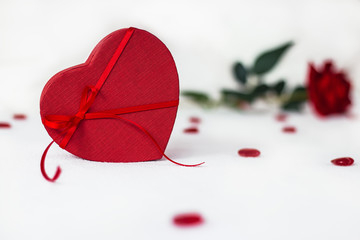 Valentines day surprise at morning on the white bed for her. Red heart background with rose with box. copy space