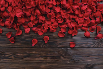 Red roses petals top view, copy space on wooden background. Love letter, valentines day concept