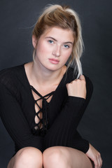 Frau im Body auf Stuhl im Fotostudio