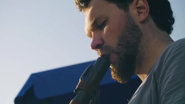 Close up portrait of musician playing ethnic flute