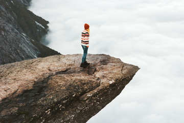 Woman explorer walking on Trolltunga rocky cliff in Norway mountains Travel Lifestyle adventure...
