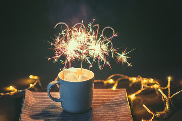 2018 Shaped Sparkler igniting in Cup with Marshmallows on outdoor table