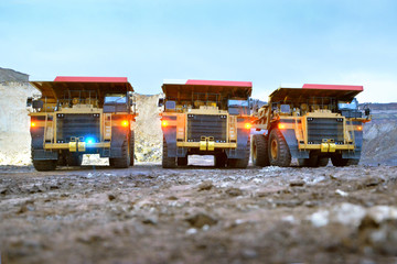 Three quarry dump trucks with included dimensions