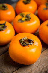 Fresh persimmon fruit on wooden table. Selective focus. Shallow depth of field.
