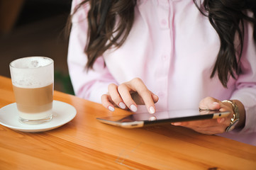 Close up hand woman using tablet in coffee shop