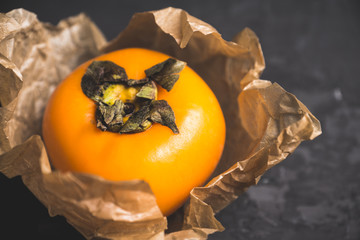 Fresh persimmon fruit on wooden table. Selective focus. Shallow depth of field.