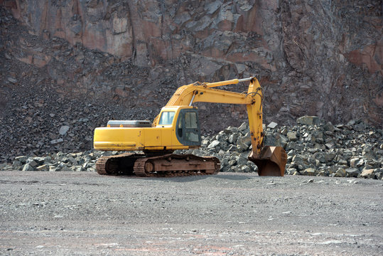 Earthmover in an active quarry mine of porphyry rocks. digging.