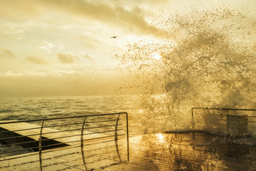 A gentle morning at the seaside. Black Sea. Wooden pier, water from the wave on the pier. Splash of...