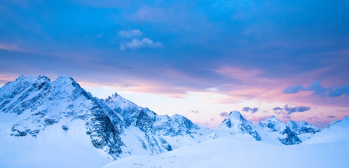 Colourful clouds and mountains in a beautiful alpine sunset in the French Alps