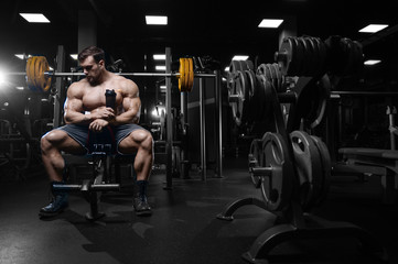 Fototapeta na wymiar Brutal strong bodybuilder athletic men pumping up muscles with dumbbells.