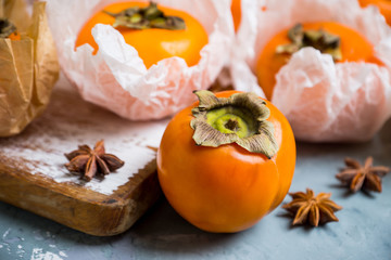 Fresh persimmon fruit on wooden table. Selective focus. Shallow depth of field.