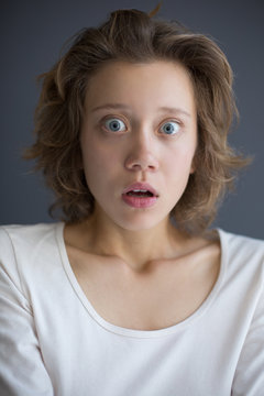 Portrait of young shocked lady amazedly looking in camera isolated