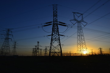 The silhouette of the evening electricity transmission pylon