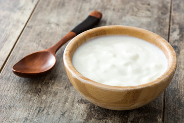 Fototapeta na wymiar Natural yogurt in wooden bowl on wooden table