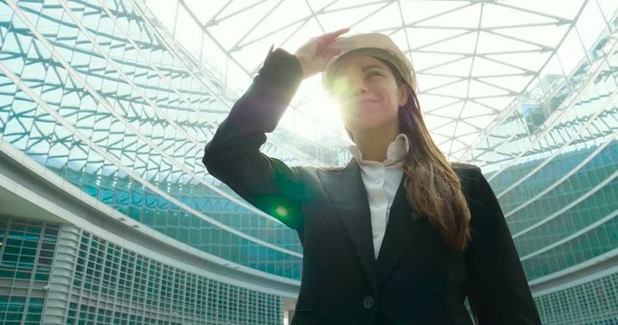 portrait of a female engineer smiling while looking at camera and in the background you can see the skyscrapers she designed.
