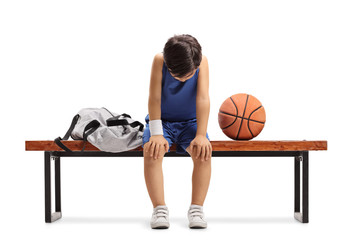 Fototapeta premium Sad little basketball player sitting on a bench