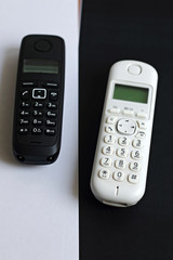 Black and white phones on white and black background