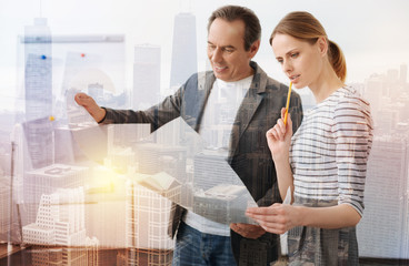 Express your ideas. Waist up of professional engineers standing in the office while working on the...