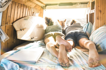Hipster couple with cute dog traveling together on vintage van transport - Life inspiration concept...